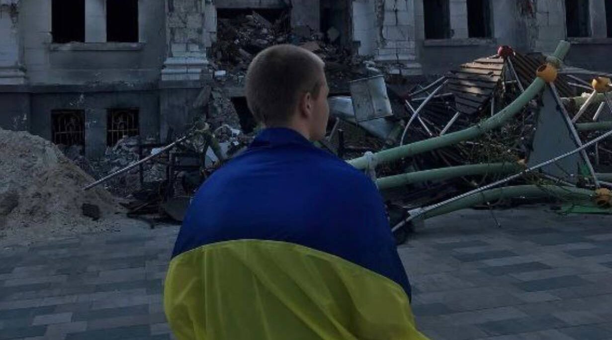У Маріуполі хлопець вийшов з прапором України біля розбомбленого Драмтеатру
